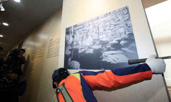 12일 오전 서울도서관에서 관계자들이 성추행 논란에 휩싸인 시인 고은의 사진을 철거하고 있다. 연합뉴스