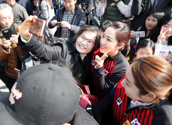여자 컬링 대표팀 김경애 선수가 12일 오전 경북 의성군청에서 열린 컬링 선수단 환영식에 참석해 한 주민과 기념사진을 찍고 있다.  연합뉴스