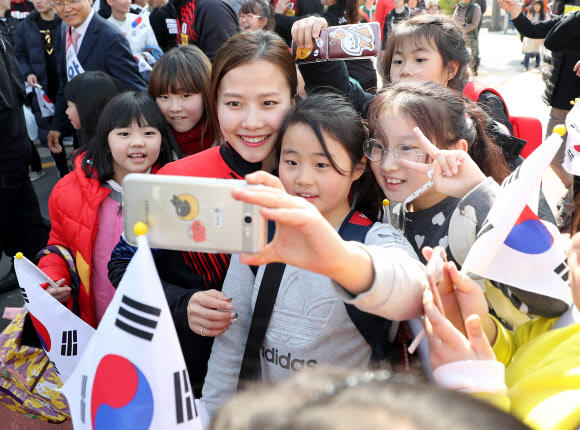 여자 컬링 대표팀 김은정 선수가 12일 오전 경북 의성군청에서 열린 컬링 선수단 환영식에 참석해 어린이들과 기념사진을 찍고 있다.  연합뉴스