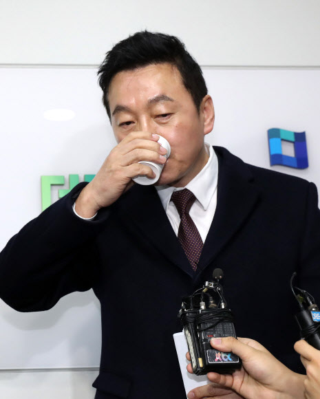 정봉주 전 의원이 15일 서울 여의도 더불어민주당 당사에서 중앙당 복당 신청서를 제출한 뒤 가진 기자회견에서 물을 마시고 있다.  연합뉴스