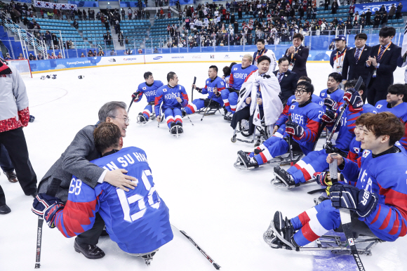 문재인 대통령과 김정숙 여사가 17일 오후 강릉하키센터에서 열린 2018 평창동계패럴림픽 아이스하키 동메달결정전, 대한민국 대 이탈리아의 경기에서 승리한 한국 선수들을 격려하고 있다. 2018.3.17 청와대제공