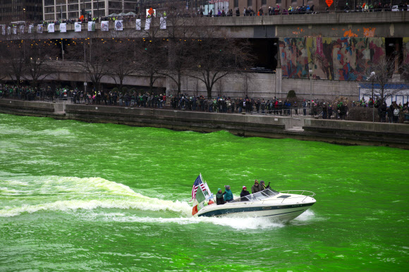 17일(현지시간) 미국 시카고 강이 초록색으로 염색돼 많은 시민들이 구경하고 있다.  AP 연합뉴스