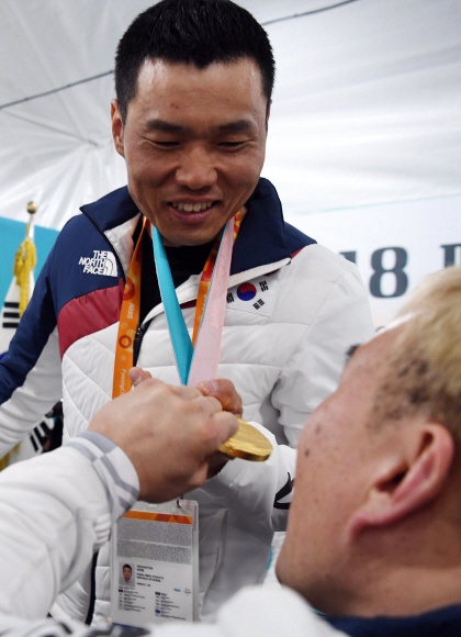 19일 오전 강원도 평창 패럴림픽 선수촌 웰컴센터에서 열린 2018 평창동계패럴림픽 대한민국 선수단 해단식에서 선수들이 신의현 선수의 금메달을 신기한듯 만져보고 있다. 2018. 3. 19. 박윤슬 기자 seul@seoul.co.kr