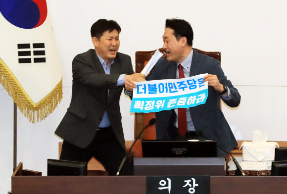 20일 오후 서울시의회 본회의장에서 더불어민주당과 자유한국당 소속 의원들이 4인 선거구 확대를 요구하며 의장석을 점거한 채 농성을 벌이는 바른미래당 소속 의원들을 끌어내고 있다.  연합뉴스