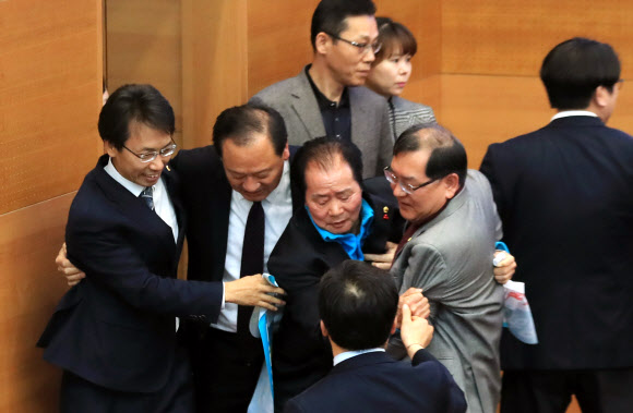 20일 오후 서울시의회 본회의장에서 더불어민주당과 자유한국당 소속 의원들이 4인 선거구 확대를 요구하며 의장석을 점거한 채 농성을 벌이는 바른미래당 소속 의원들을 끌어내고 있다.  연합뉴스