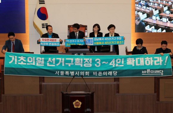 20일 오후 서울시의회 본회의장에서 바른미래당 의원들이 기초의원 선거구획정 3~4인 확대가 적힌 현수막을 들고 있다.  연합뉴스