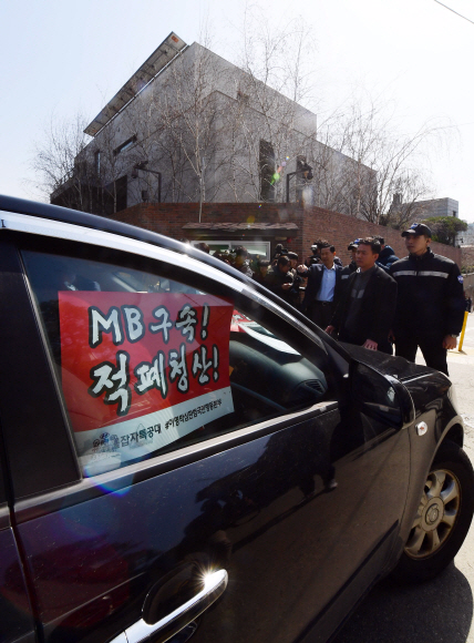 법원이 이명박 전 대통령 구속영장에 대한 서류심사를 한 22일 서울 논현동 이 전 대통령 자택 앞에서 한 시민이 이 전 대통령의 구속을 요구하는 손팻말을 차에 붙이고 사저로 진입하려다 경찰의 저지를 받고  있다.  정연호 기자 tpgod@seoul.co.kr