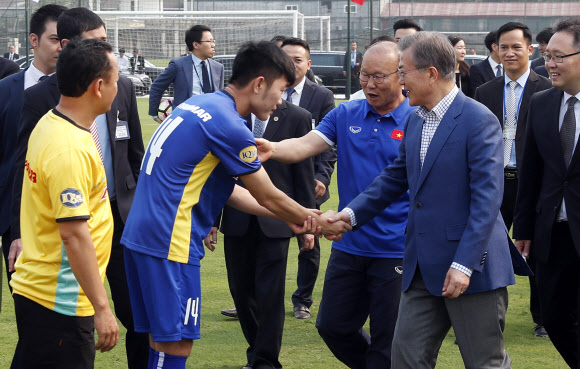 문재인 대통령이 22일 오후 베트남 국빈방문 첫 일정으로 베트남 축구협회를 방문, 지난 1월 베트남 U-23 국가대표팀을 아시아축구연맹(AFC) 준우승에 올려놓아 베트남의 국민적 영웅으로 떠오른 박항서 감독의 안내를 받으며 루엉 쑤언 쯔엉 축구대표팀 주장을 비롯한 선수들을 격려하고 있다.  연합뉴스