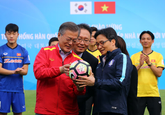 문재인 대통령과 부인 김정숙 여사가 22일 오후 베트남 국빈방문 첫 일정으로 베트남 축구협회를 방문, 부 득 담 베트남 부총리(오른쪽)로부터 베트남 축구 국가대표 선수팀 사인이 담긴 공을 선물받은 뒤 대통령과 김여사 사인이 담긴 공을 선물하고 있다.  연합뉴스