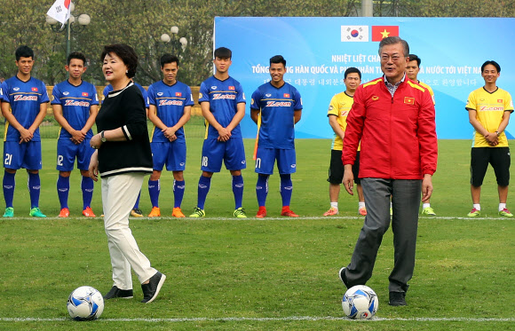문재인 대통령과 부인 김정숙 여사가 22일 오후 베트남 국빈방문 첫 일정으로 베트남 축구협회를 방문, 베트남 축구 국가대표팀을 격려한 뒤 시축하기 앞서 몸을 풀고 있다.  연합뉴스