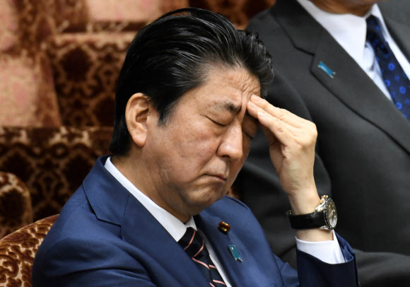 아베 신조 일본 총리가 26일 일본 도쿄 국회에서 열린 참의원 예산위원회에서 머리를 감싸 쥔 채 생각에 잠겨있다. AFP 연합뉴스