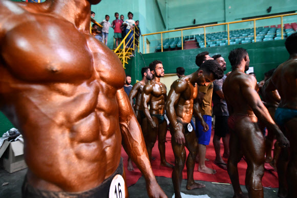 25일(현지시간) 인도 아삼주 구와하티 에서 열린 보디빌딩 챔피언십에 참가한 선수들이 무대에 오를 준비를 하고 있다. AFP 연합뉴스