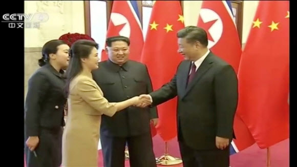 중국 중앙(CC)TV는 28일 시진핑 중국 국가주석의 초청을 받아 김정은 북한 노동당 위원장이 방중했다고 보도했다. 김 위원장의 부인 리설주와 시진핑 중국 국가주석이 인사를 나누고 있다. 로이터 연합뉴스
