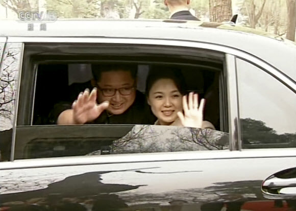 28일 중국 CCTV는 김정은(왼쪽) 위원장과 부인 리설주가 차창 밖으로 손을 흔드는 모습을 공개했다. 당시 차 밖에선 시 주석과 부인 펑리위안이 김 위원장 부부를 배웅하고 있었다. CCTV 캡처