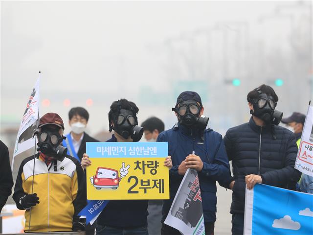 올해 들어 네 번째 서울형 미세먼지 비상저감조치가 시행된 지난 26일 서울 광화문사거리에서 열린 ‘차량 2부제 100만 시민 참여와 미세먼지 줄이기를 위한 시민 주도 캠페인’에서 참가자들이 방독면을 쓴 채 미세먼지 줄이기 캠페인 동참을 호소하고 있다. 이날 캠페인에는 녹색서울시민위원회와 맑은하늘만들기시민운동본부 등 시민단체와 회원 1200여명이 참여했다.  연합뉴스