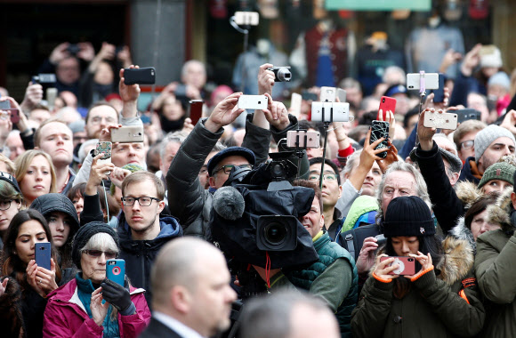 시민들과 촬영기자들이 영국의 천체물리학자 스티븐 호킹의 장례식이 열린 31일(현지시간) 케임브리지의 세인트 메리 대성당 앞에서 스마트폰과 카메라 등으로 촬영하고 있다. 2018.3.31  로이터=연합뉴스