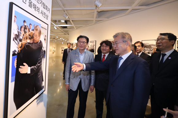 문재인 대통령이 2일 오후 서울 종로구 세종문화회관 미술관에서 열린 제54회 한국보도사진전을 찾아 이동희 한국사진기자협회장의 안내로 전시된 사진을 관람하고 있다. 2018.4.2 안주영기자 jya@seoul.co.kr