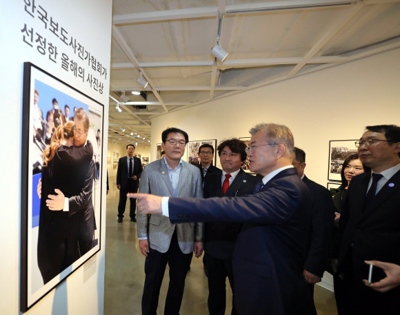 문재인 대통령이 2일 오후 서울 종로구 세종문화회관 미술관에서 열린 제54회 한국보도사진전을 찾아 이동희 한국사진기자협회장의 안내로 전시된 사진을 관람하고 있다.2018.4.2 안주영기자 jya@seoul.co.kr