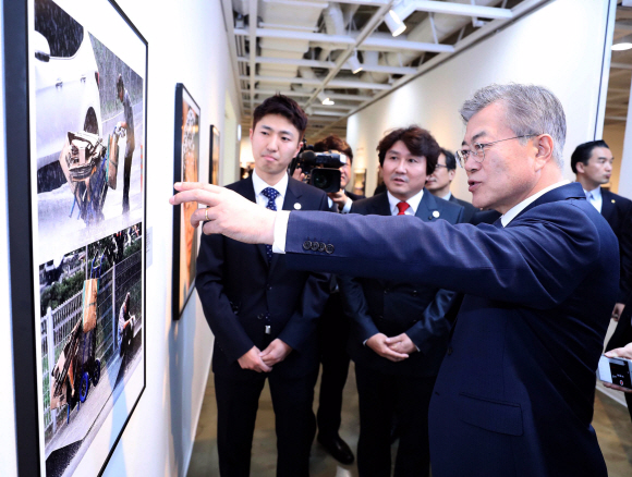 문재인 대통령이 2일 오후 서울 종로구 세종문화회관 미술관에서 열린 제54회 한국보도사진전을 찾아 이동희 한국사진기자협회장의 안내로 전시된 사진을 관람하고 있다.2018.4.2 안주영기자 jya@seoul.co.kr