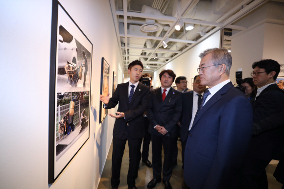 문재인 대통령이 2일 오후 서울 종로구 세종문화회관 미술관에서 열린 제54회 한국보도사진전을 찾아 이동희 한국사진기자협회장의 안내로 전시된 사진을 관람하고 있다.2018.4.2 안주영기자 jya@seoul.co.kr