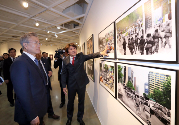 문재인 대통령이 2일 오후 서울 종로구 세종문화회관 미술관에서 열린 제54회 한국보도사진전을 찾아 이동희 한국사진기자협회장의 안내로 전시된 사진을 관람하고 있다. 2018.4.2 안주영기자 jya@seoul.co.kr