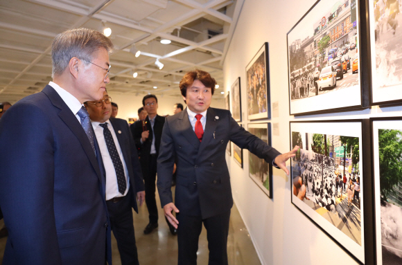 문재인 대통령이 2일 오후 서울 종로구 세종문화회관 미술관에서 열린 제54회 한국보도사진전을 찾아 이동희 한국사진기자협회장의 안내로 전시된 사진을 관람하고 있다. 2018.4.2 안주영기자 jya@seoul.co.kr