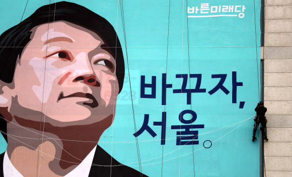 ‘6·13 지방선거’ 서울시장 출마를 선언한 바른미래당 안철수 인재영입위원장의 종로구 캠프 사무실에서 관계자들이 건물 외벽에 현수막을 내걸고 있다.  연합뉴스