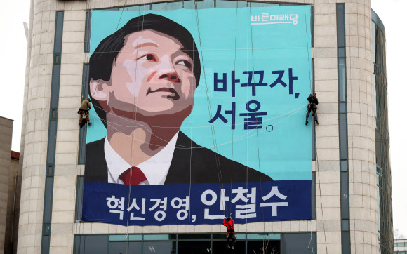 ‘6·13 지방선거’ 서울시장 출마를 선언한 바른미래당 안철수 인재영입위원장의 종로구 캠프 사무실에서 관계자들이 건물 외벽에 현수막을 내걸고 있다.  연합뉴스