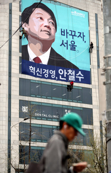 ‘6·13 지방선거’ 서울시장 출마를 선언한 바른미래당 안철수 인재영입위원장의 종로구 캠프 사무실에서 관계자들이 건물 외벽에 현수막을 내걸고 있다.  연합뉴스