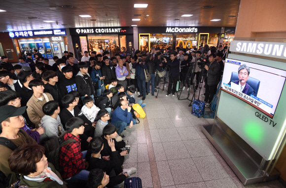 6일 오후 서울역 대합실에서 승객들이 박근혜 전 대통령의 1심 선고공판 생중계를 시청하고 있다. 이호정 전문기자 hojeong@seoul.co.kr