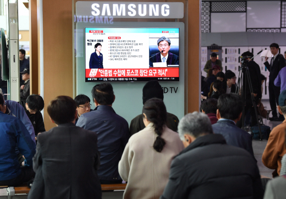 6일 오후 서울역 대합실에서 승객들이 박근혜 전 대통령의 1심 선고공판 생중계를 시청하고 있다. 이호정 전문기자 hojeong@seoul.co.kr
