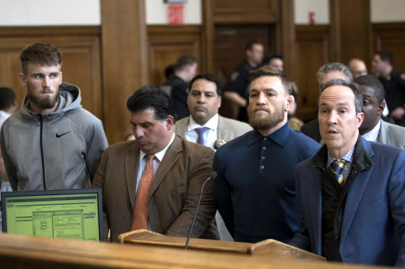   UFC 버스를 파손하는 난동을 주도한 혐의로 기소된 코너 맥그레거(오른쪽 두 번째)가 변호인과 함께 6일(현지시간) 미국 뉴욕 브루클린 형사법정에서 인정신문을 받고 있다. 왼쪽은 그의 친구이자 UFC 선수인 시안 콜리. 브루클린 AP 연합뉴스 