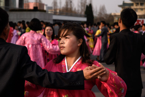 북한 김정일의 국방위원장 추대 25주년인 9일 평양 실내체육관 바깥에서 대규모 무도회에 참석한 대학생들이 춤을 추고 있다. 한 매체는 이날 밤 10시 현재까지 중앙보고대회가 열렸다는 보도를 하지 않고 있다. 김정은 체제 들어서도 행사가 생략된 적이 없었다. AFP 연합뉴스
