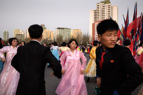 북한 김정일의 국방위원장 추대 25주년인 9일 평양 실내체육관 바깥에서 대규모 무도회에 참석한 대학생들이 춤을 추고 있다. 한 매체는 이날 밤 10시 현재까지 중앙보고대회가 열렸다는 보도를 하지 않고 있다. 김정은 체제 들어서도 행사가 생략된 적이 없었다. AFP 연합뉴스