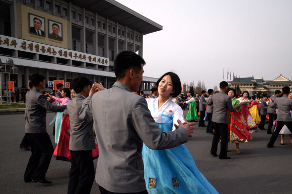 북한 김정일의 국방위원장 추대 25주년인 9일 평양 실내체육관 바깥에서 대규모 무도회에 참석한 대학생들이 춤을 추고 있다. 한 매체는 이날 밤 10시 현재까지 중앙보고대회가 열렸다는 보도를 하지 않고 있다. 김정은 체제 들어서도 행사가 생략된 적이 없었다. AFP 연합뉴스