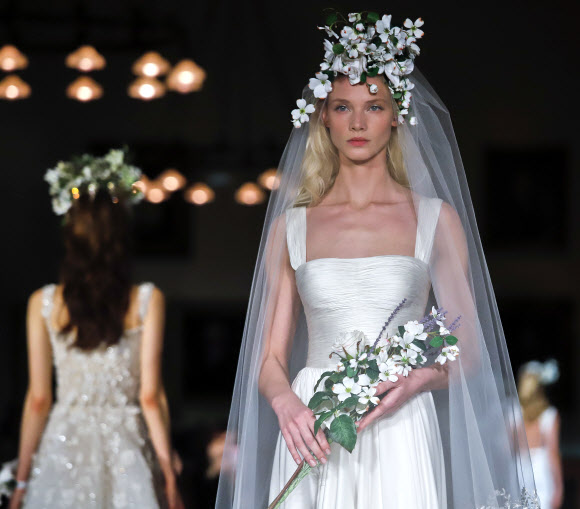 12일(현지시간) 미국 뉴욕에서 열린 ‘브라이들 패션 위크(Bridal Fashion Week)’에서 모델이 디자이너 림 아크라(Reem Accra)의 웨딩드레스 컬렉션을 선보이고 있다. AP 연합뉴스