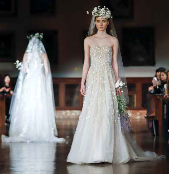 12일(현지시간) 미국 뉴욕에서 열린 ‘브라이들 패션 위크(Bridal Fashion Week)’에서 모델이 디자이너 림 아크라(Reem Accra)의 웨딩드레스 컬렉션을 선보이고 있다. AP 연합뉴스