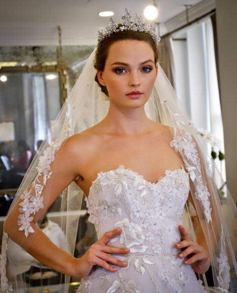 12일(현지시간) 미국 뉴욕에서 열린 ‘브라이들 패션 위크(Bridal Fashion Week)’에서 모델이 디자이너 로모나 케베자(Romona Keveza)의 웨딩드레스를 선보이고 있다. AP 연합뉴스