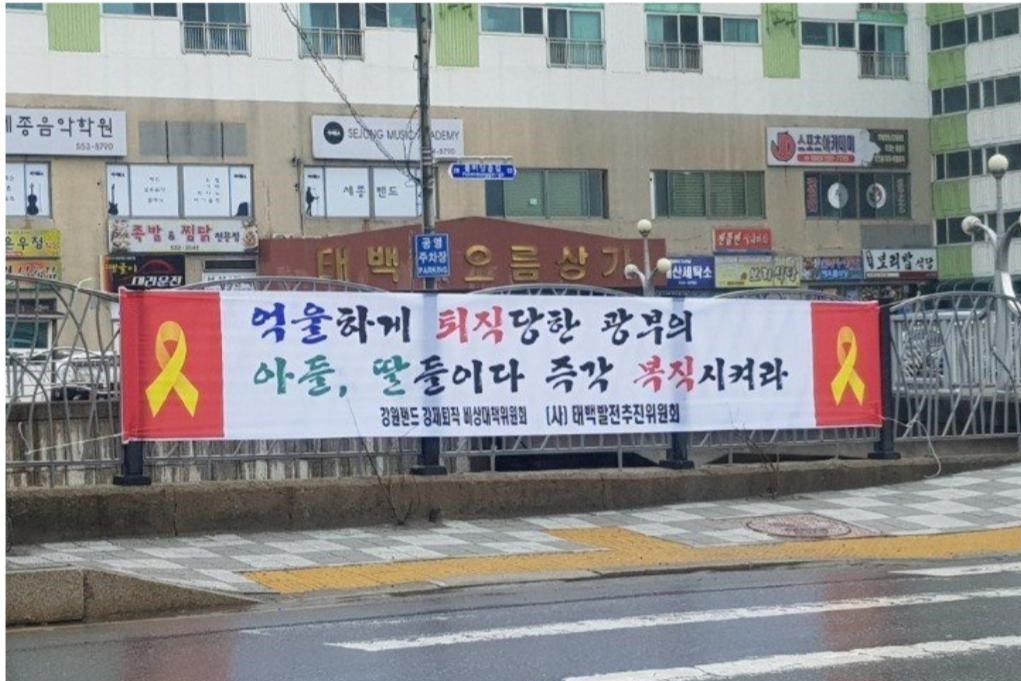 강원랜드 강제퇴직 비상대책위원회 측이 내건 것으로 보이는 현수막. 좌우 가장자리에 붉은색 배경으로 노란 리본이 배치돼 있다. 온라인 커뮤니티 사이트 캡처