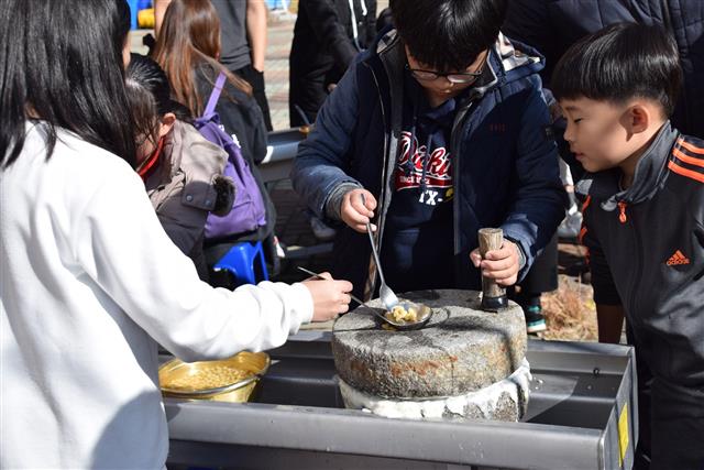 한국농어촌공사가 운영하는 ‘중소기업 가족연수’ 프로그램에 참여한 아이들이 직접 콩을 맷돌에 갈아 두부를 만들고 있다.  한국농어촌공사 제공