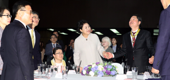 문재인 대통령 부인 김정숙 여사가 20일 오전 서울 여의도 63빌딩에서 열린 ’제38회 장애인의 날 기념식’에 참석해 장애인들의 손을 맞잡고 합창을 하고 있다. 2018. 04. 20 청와대사진기자단