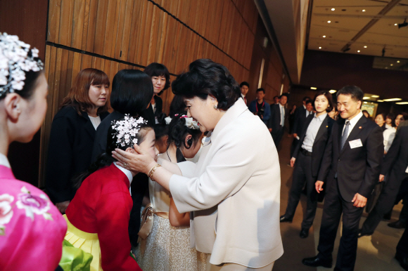 문재인 대통령 부인 김정숙 여사가 20일 오전 서울 여의도 63빌딩에서 열린 ’제38회 장애인의 날 기념식’ 행사를 마친 후 무대에 오른 어린이를 격려하고 있다. 2018. 04. 20 청와대사진기자단