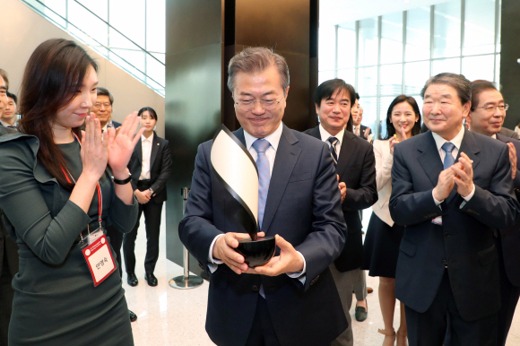 문재인 대통령이 20일 오전 민간주도 혁신성장 현장 격려 일환으로 방문한 서울 마곡R&D산업단지 LG 사이언스파크에서 한 관계자로부터 OLED캔들을 건네 받고 있다. 2018. 04. 20 청와대사진기자단