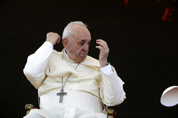 프란치스코 교황이 20일(현지시간) 이탈리아 Alessano에서 Bishop Tonino Bello의 무덤서 ‘제25회 추모식’ 중 기도를 끝내고 돌풍에 모관이 날아가 당황한 모습이 포착되고 있다. AP 연합뉴스