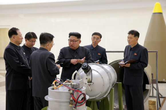 북한은 지난 20일 노동당 중앙위원회 제7기 제3차 전원회의에서 21일부터 핵시험과 대륙간탄도로켓(ICBM) 시험 발사를 중지하고 풍계리 핵실험장을 폐기하겠다는 내용의 결정서를 채택했다. 사진은 김정은 북한 국무위원장이 지난해 9월 핵무기연구소를 방문해 과학자로부터 새로 제작한 대륙간탄도로케트 전투부에 장착할 수소탄에 대한 설명을 듣고 있는 모습. EPA 연합뉴스