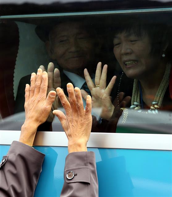 제20차 남북이산가족상봉 2차 작별상봉행사에서 먼저 버스에 오른 남측 가족을 향해 북측 가족들이 손을 흔들고 있다.