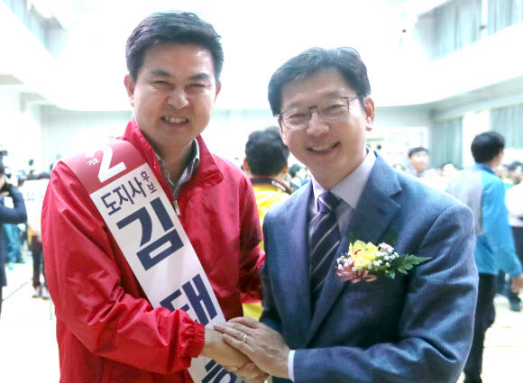 경남도지사 출마선언을 한 더불어민주당 김경수 의원(오른쪽)과 자유한국당 김태호 전 의원이 26일 오전 경남 김해 장유 스포츠센터에서 열린 김해시 아파트 관리직원 체육대회에 참석해 악수하고 있다.  연합뉴스