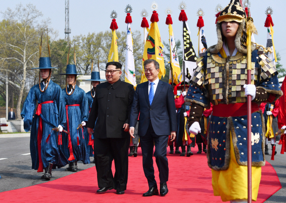 문재인 대통령과 김정은 국무위원장이 27일 오전 판문점에서 만나 인사를 나눈 후  공식 환영식장으로 이동하고 있다.  안주영 기자 jya@seoul.co.kr