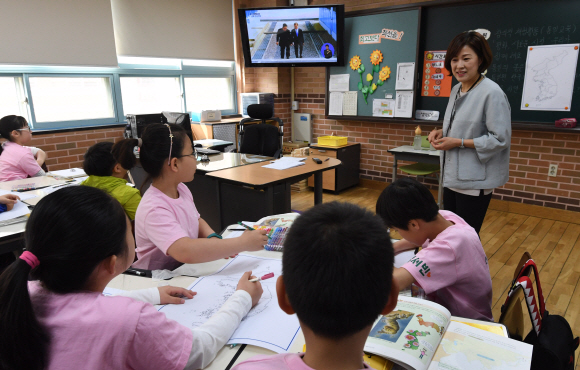 27일 오전 서울 양천구 신은초등학교 학생들이 문재인 대통령과 김정은 북한 국무위원장이 판문점에서 만나는 모습이 생중계되는 TV를 시청하며 남북 정상회담의 의미에 대해 이야기하고 있다.  도준석 기자 pado@seoul.co.kr