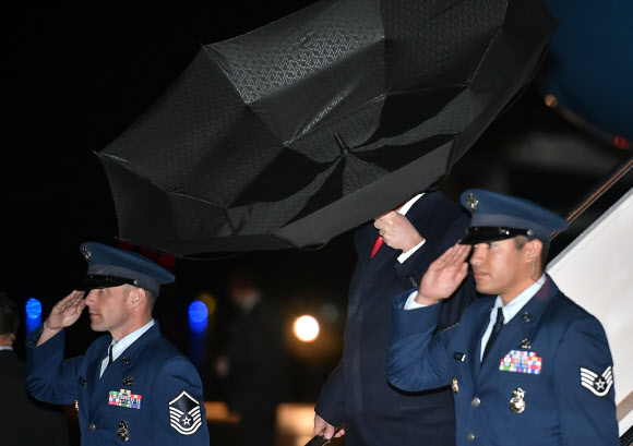 도널드 트럼프 미국 대통령이 28일(현지시간) 미국 워싱턴의 DC 앤드루스 공군 기지에 도착해 미국 대통령 전용기 에어 포스 원에서 내려오고 있는데 강풍에 우산이 뒤집어지고 있다. AFP 연합뉴스